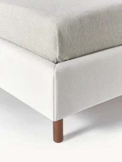 Cama tapizada con patas de madera Giulia