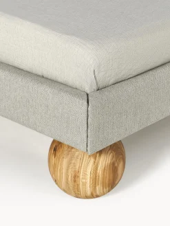 Cama tapizada con patas esfericas de madera Rena