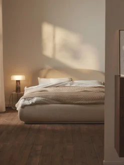 Cama tapizada redondeada en tejido bouclé Alba